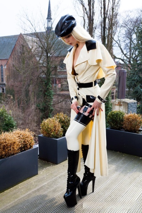 Hot blonde flashes latex garters while modeling outdoors in rubber attire 15675992